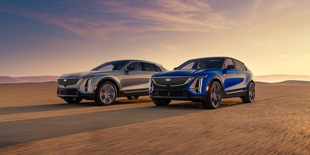 2026 Cadillac LYRIQ electric SUVs in blue and silver driving at sunset, highlighting premium luxury, cutting-edge EV technology, and modern Cadillac design.